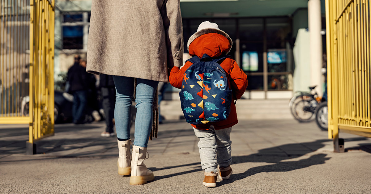 A mother entering the childcare yard with her boy